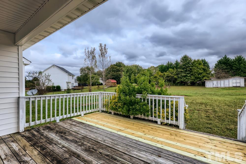 386 Rosa Circle Willow Spring, NC 27592 - Photo 23 of 27 a view of a wooden deck and a yard