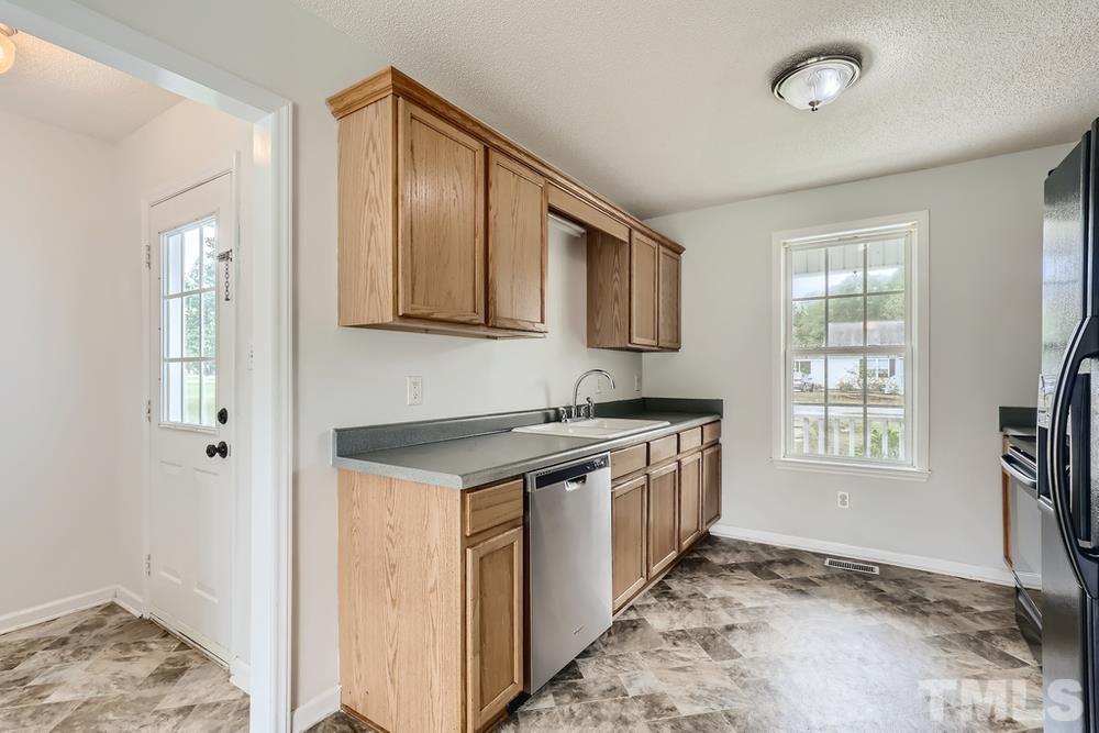 386 Rosa Circle Willow Spring, NC 27592 - Photo 8 of 27 a kitchen with stainless steel appliances granite countertop a stove a sink and a refrigerator