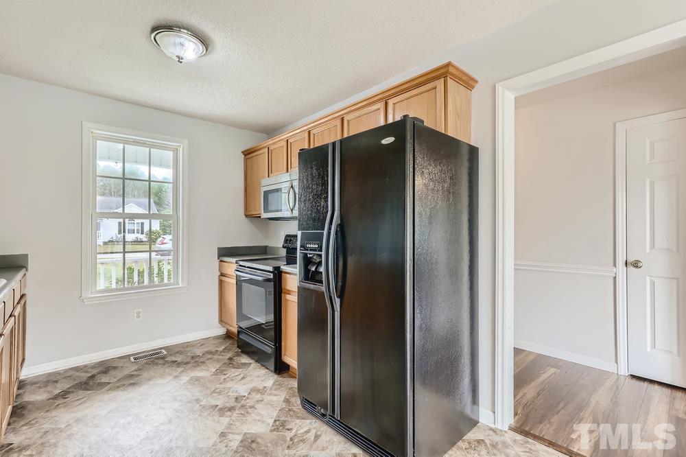 386 Rosa Circle Willow Spring, NC 27592 - Photo 9 of 27 a kitchen with a refrigerator and a sink
