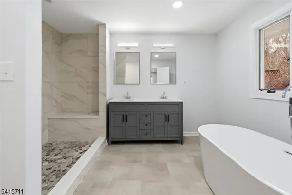 a bathroom with a bathtub sink and mirror