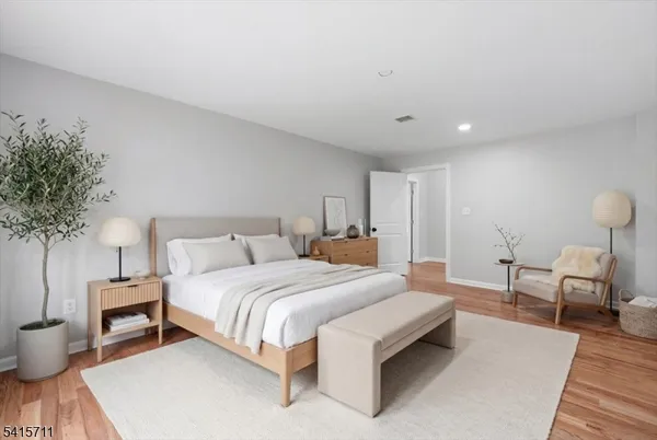 a bedroom with a large bed and a potted plant