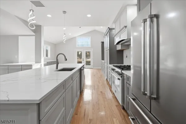 a kitchen with stainless steel appliances a sink stove and refrigerator