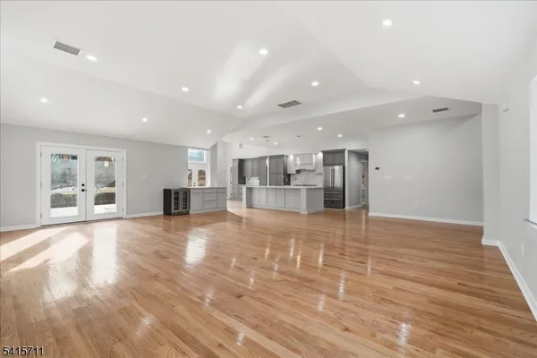 a view of an empty room with wooden floor