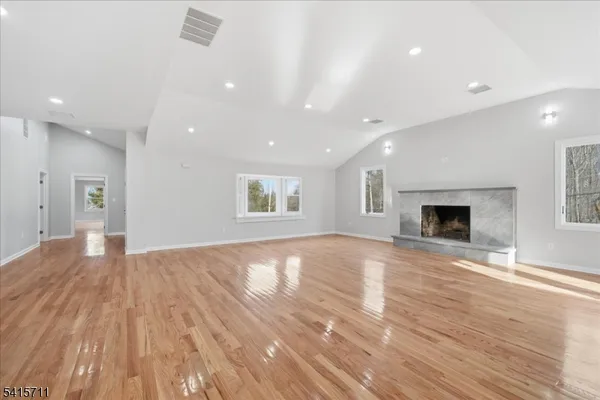 an empty room with wooden floor and fireplace