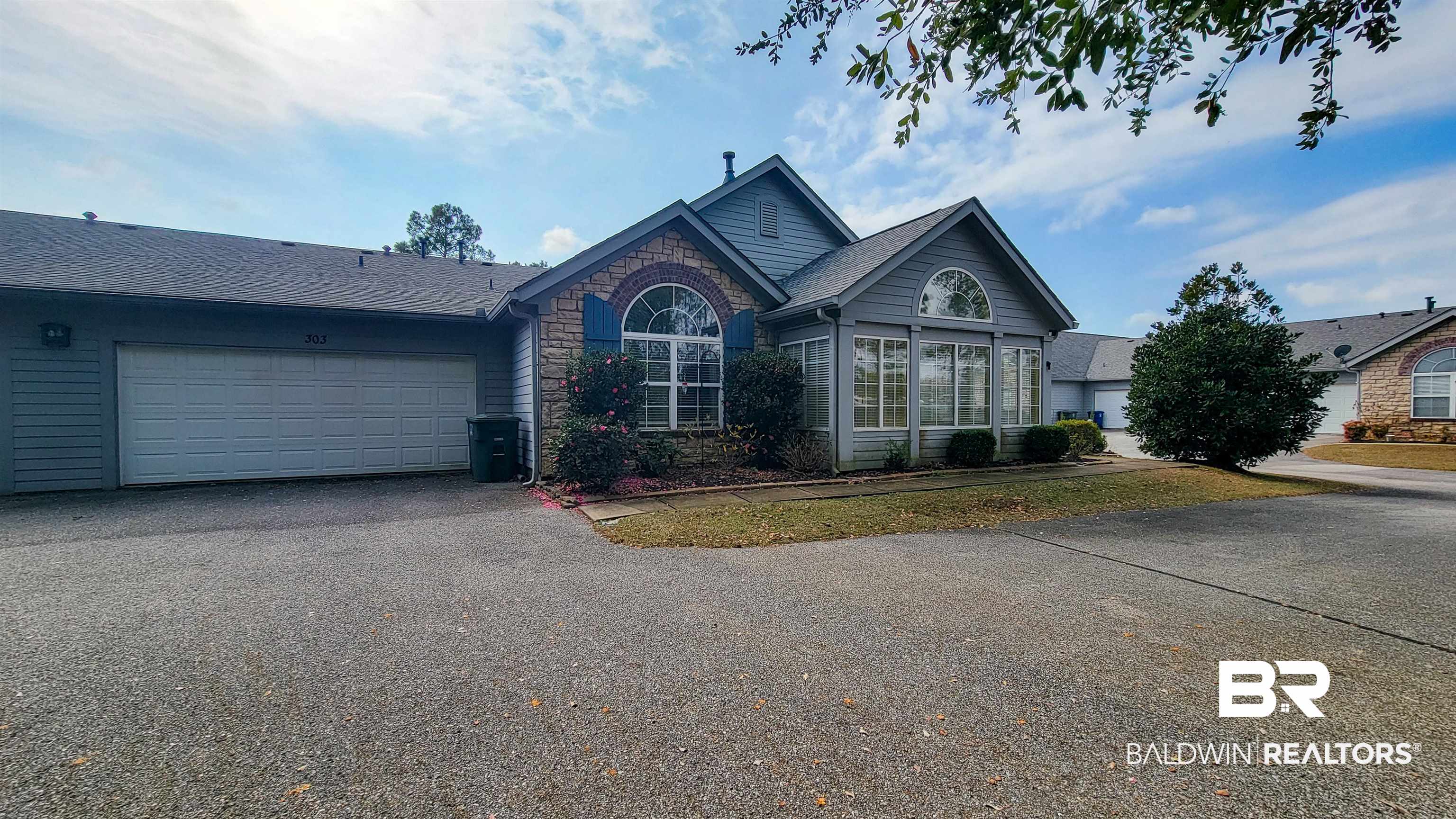 303 Wyld Palms Drive, Unit 303 Foley, AL 36535 - Photo 31 of 36 Ranch-style home featuring stone siding, driveway, a garage, and a shingled roof