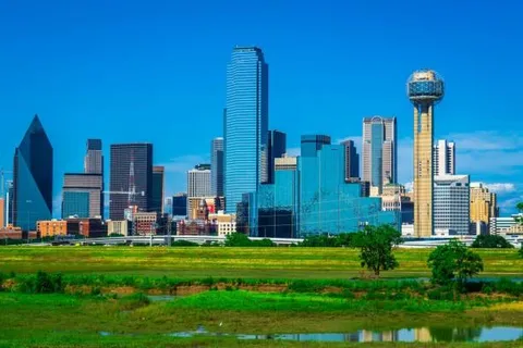 a view of a city with tall buildings and a big yard