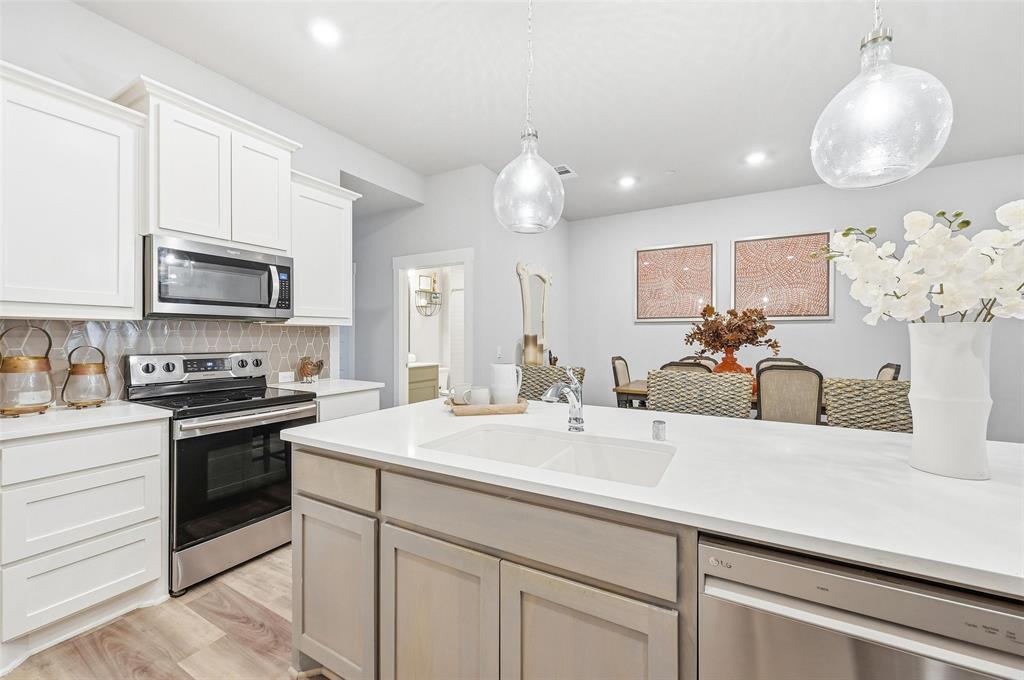 7236 Calistoga Lane Grand Prairie, TX 75054 - Photo 17 of 40 a kitchen with kitchen island white cabinets appliances and a sink