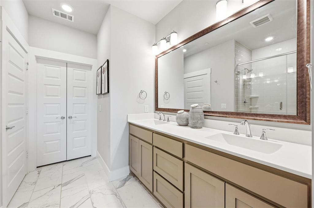 7236 Calistoga Lane Grand Prairie, TX 75054 - Photo 28 of 40 a bathroom with a double vanity sink a mirror and a shower