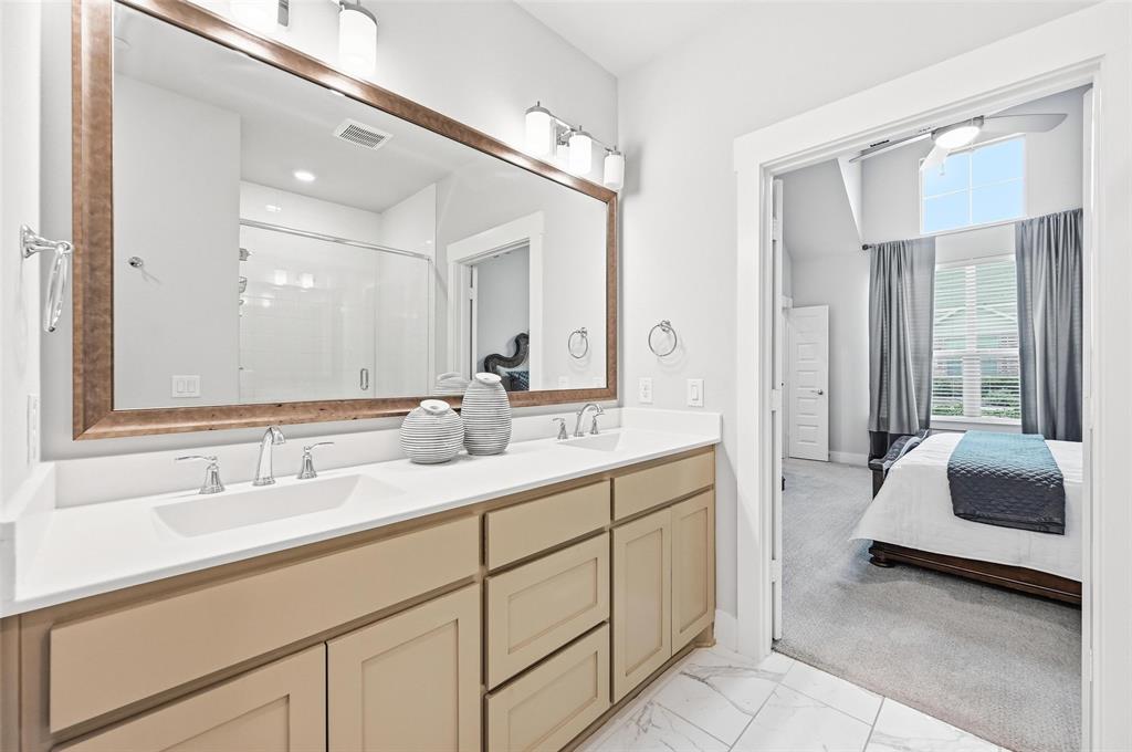 7236 Calistoga Lane Grand Prairie, TX 75054 - Photo 30 of 40 a en suite bathroom with a double vanity sink a mirror and a bathtub