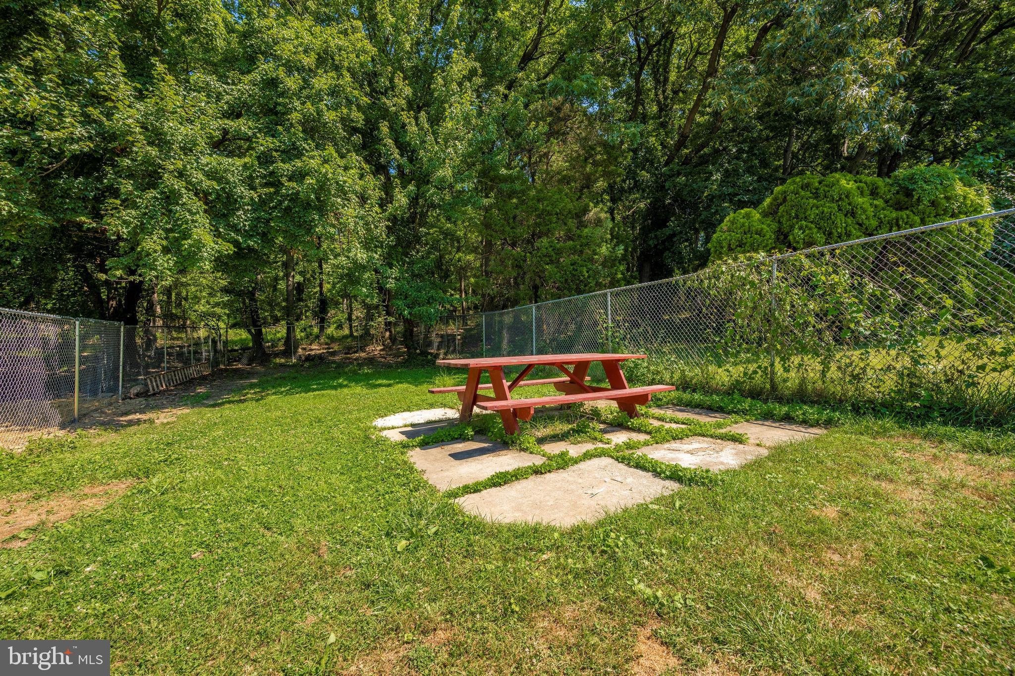 4304 Ridge Avenue Baltimore, MD 21227 - Photo 43 of 50 a view of a park with large trees and a wooden fence