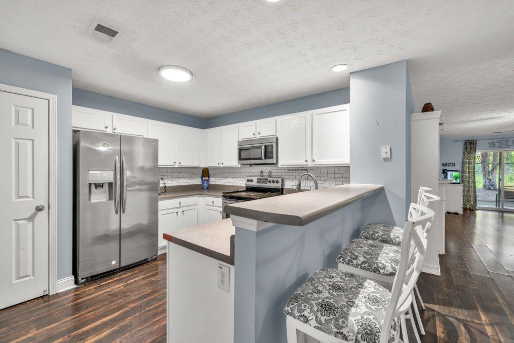 233 Tara Commons Walk Loganville, GA 30052 - Photo 11 of 52 a kitchen with a refrigerator a sink and a stove top oven