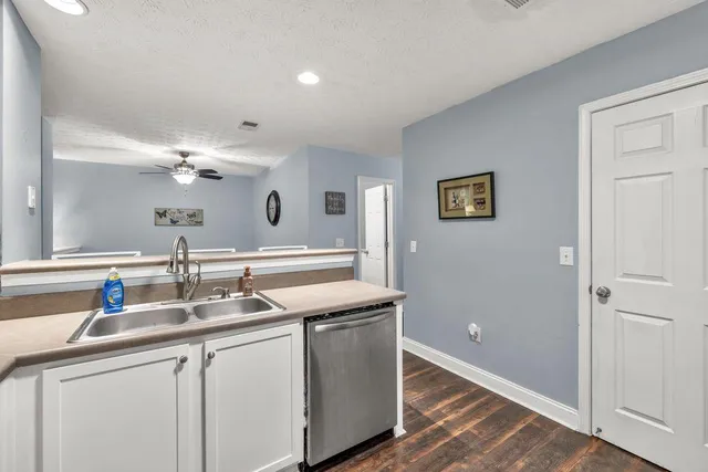 a kitchen with granite countertop white cabinets and white appliances