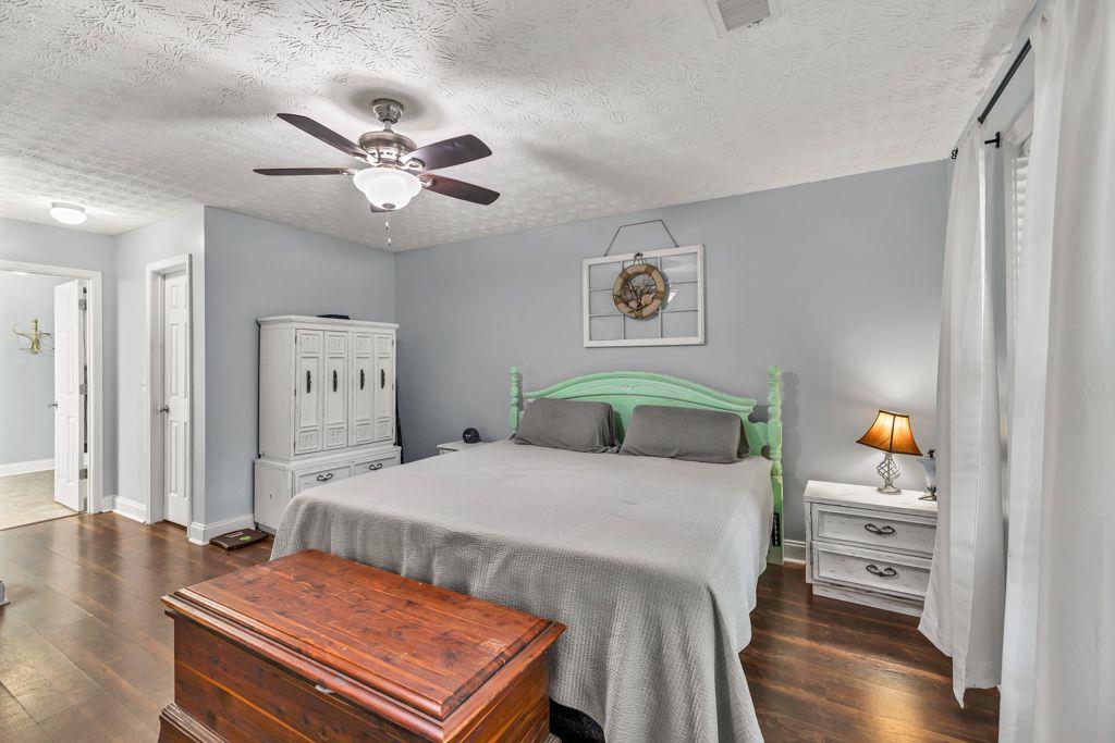 233 Tara Commons Walk Loganville, GA 30052 - Photo 23 of 52 a bedroom with a bed and wooden floor