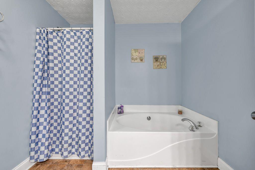 233 Tara Commons Walk Loganville, GA 30052 - Photo 26 of 52 a white bath tub sitting next to a white cabinet