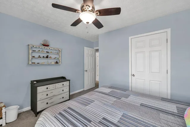 a bedroom with a bed and a ceiling fan