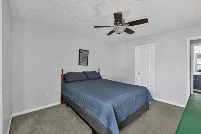 a spacious bedroom with a bed chandelier and a window