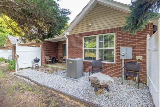 a backyard of a house with barbeque oven table and chairs