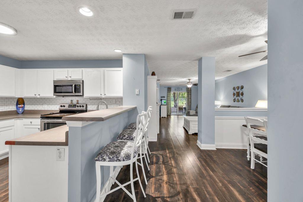 233 Tara Commons Walk Loganville, GA 30052 - Photo 9 of 52 a large kitchen with cabinets wooden floor and stainless steel appliances