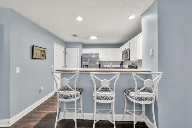 a kitchen with a refrigerator a sink and a stove top oven