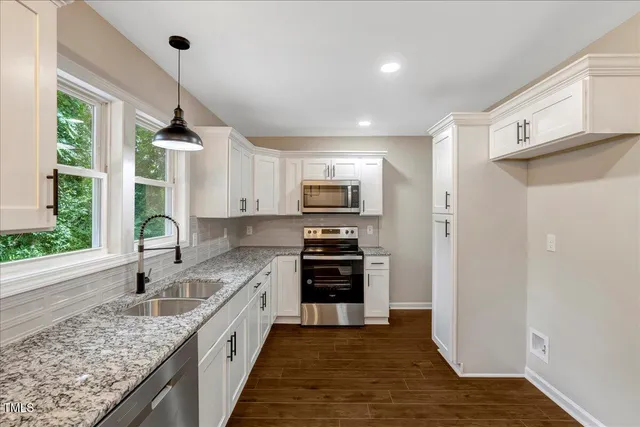 a kitchen with stainless steel appliances granite countertop a refrigerator and a sink
