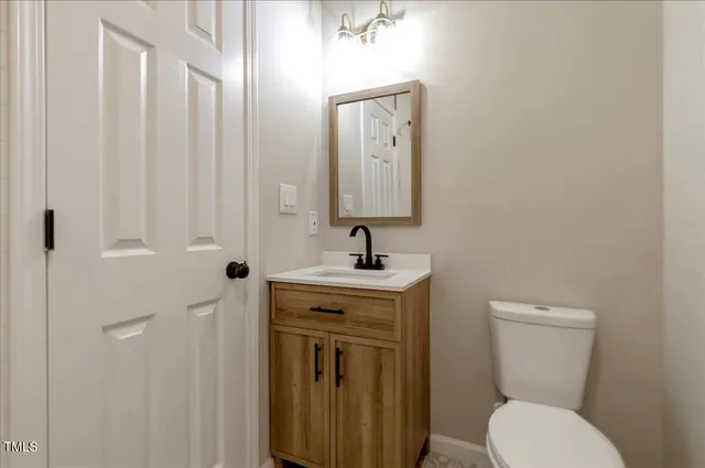 a bathroom with a toilet a sink and mirror