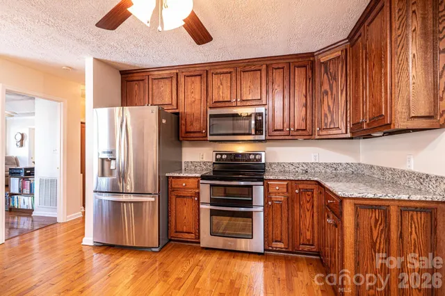 a kitchen with stainless steel appliances granite countertop a refrigerator microwave and stove top oven