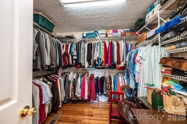 a view of walk in closet with clothes