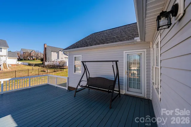 a view of a chairs and table on the wooden floor in front of house
