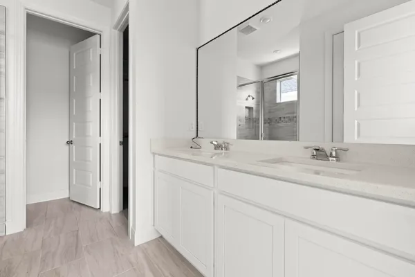 a bathroom with double vanity sinks and a mirror