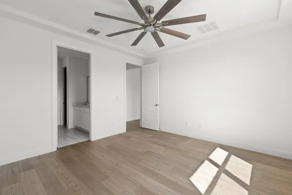 an empty room with a window and a fan