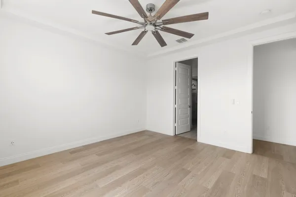 an empty room with a fan and a ceiling fan