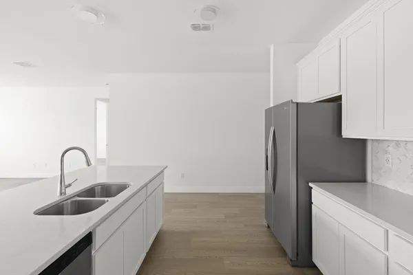 a kitchen with a refrigerator sink and cabinets