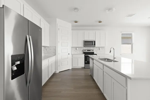 a kitchen with stainless steel appliances a refrigerator stove microwave and sink