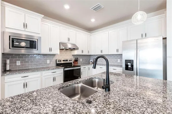 a large kitchen with kitchen island a large window in it