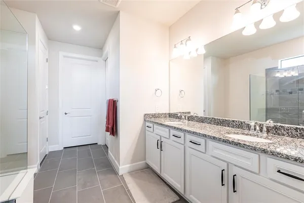 a bathroom with a granite countertop sink a mirror and a shower