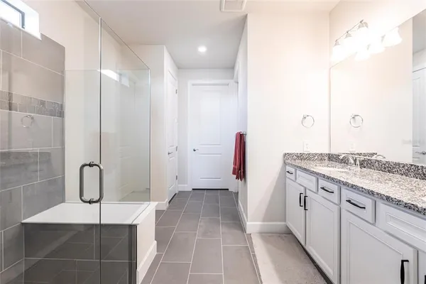 a bathroom with a granite countertop sink a toilet and shower