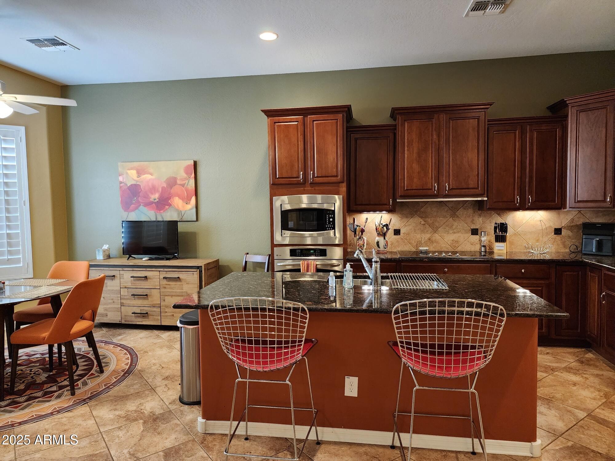 20002 North 269th Drive Buckeye, AZ 85396 - Photo 6 of 29 a kitchen with stainless steel appliances granite countertop a stove a sink a microwave and a refrigerator