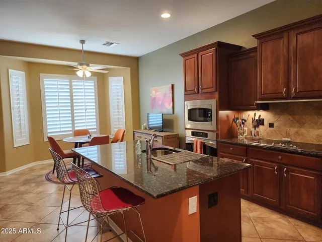 a kitchen with granite countertop a stove a sink and dishwasher wooden cabinets with wooden floor