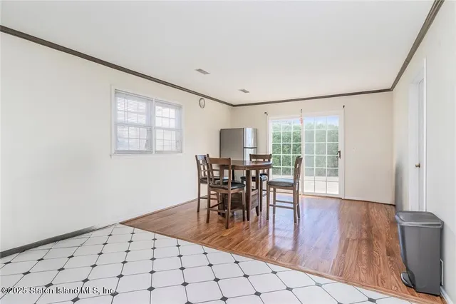 a dining room with wooden floor and large window