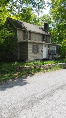 a front view of house with yard and trees