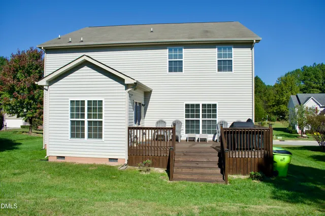 a view of a house with a small yard and wooden fence