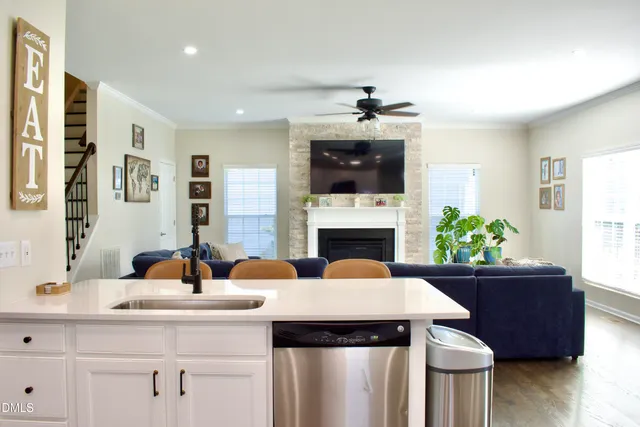 a kitchen with stainless steel appliances granite countertop a sink a stove and white cabinets