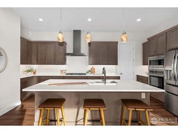 a kitchen with stainless steel appliances a sink a stove top oven a counter space and cabinets