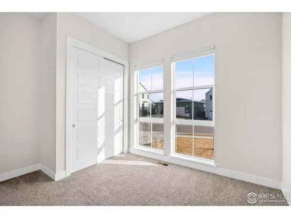 a bedroom with furniture and a large window