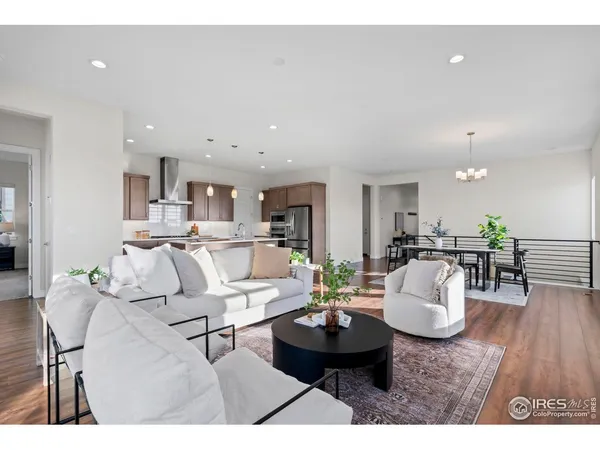 a view of a dining room and livingroom with furniture wooden floor a chandelier