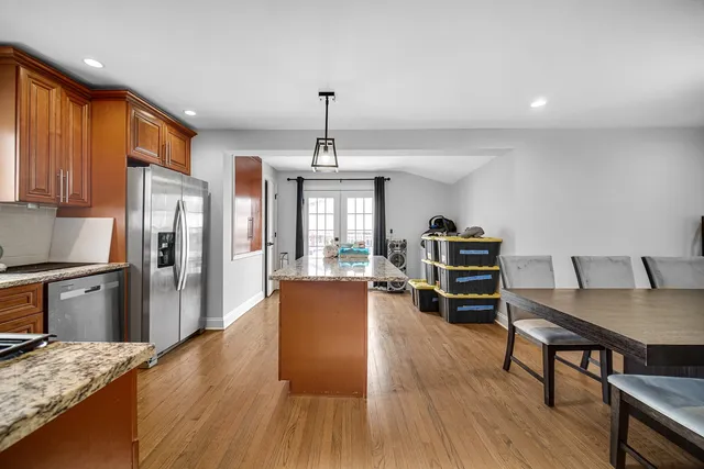 a living room with stainless steel appliances granite countertop furniture and wooden floor