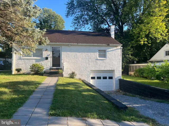 a view of a house with a yard and a large tree