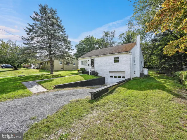 a view of a house with a yard and park