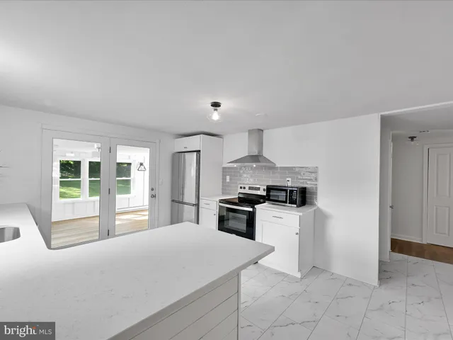 a kitchen with stainless steel appliances granite countertop a stove a sink and a refrigerator