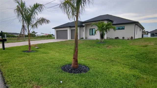 a front view of house with yard and palm tree